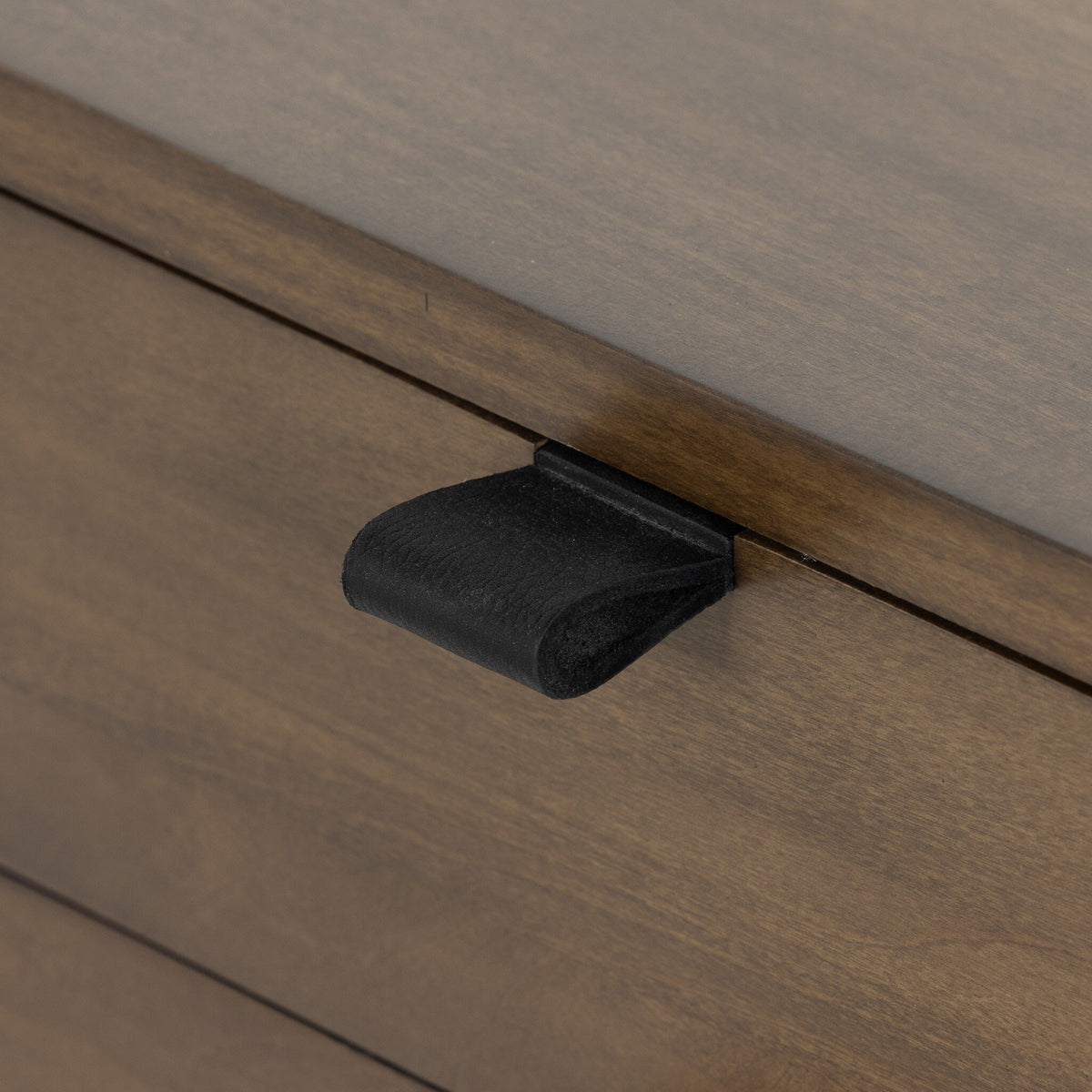 a black handle on a wooden drawer