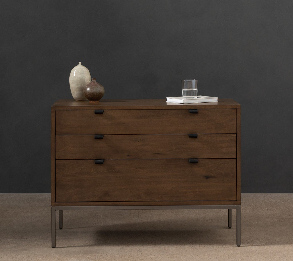a dresser with a vase and a glass on top