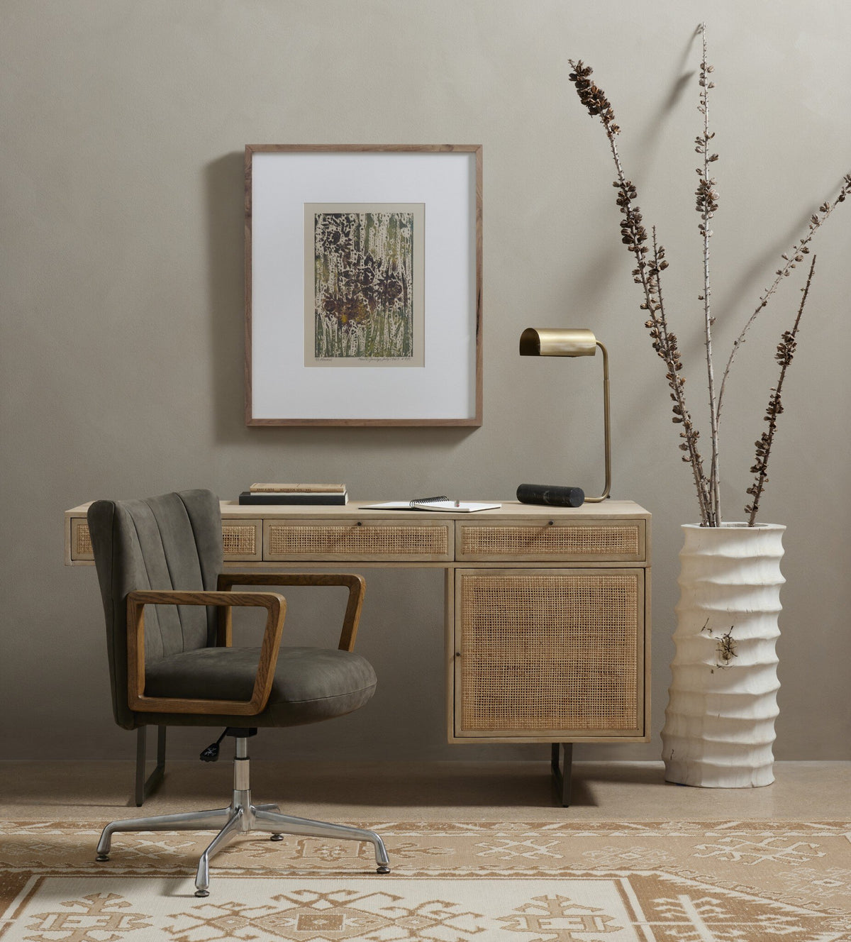 a desk with a chair and a plant in a vase