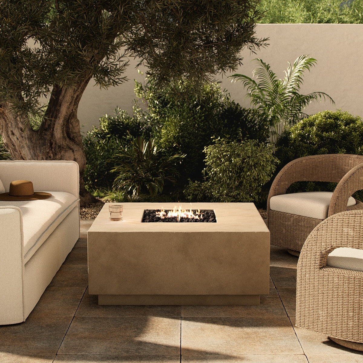 a fire pit with chairs and a tree in the background