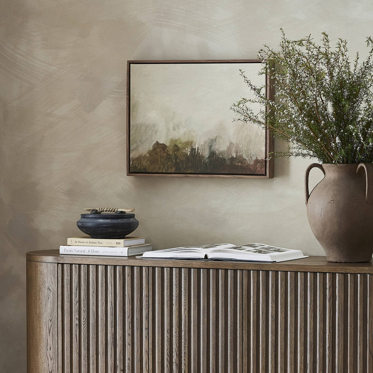 a vase and books on a cabinet