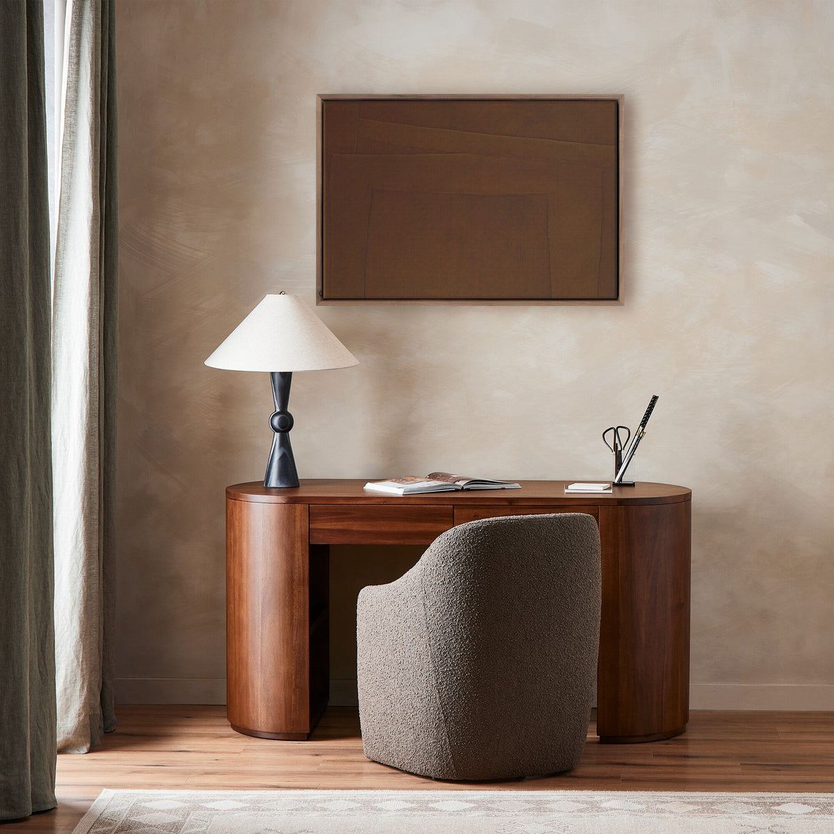 a desk with a lamp and a framed picture on the wall