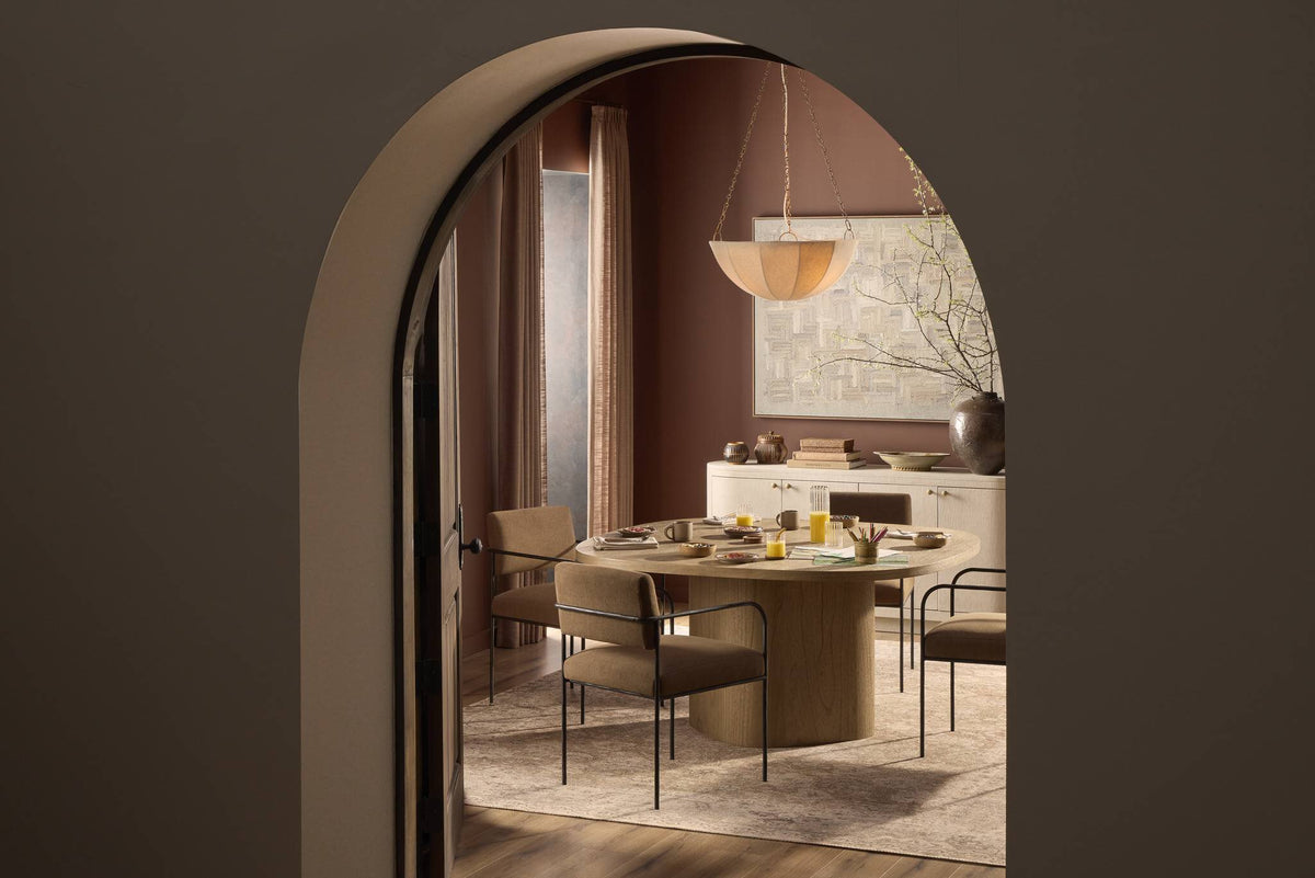 a dining room with a round table and chairs