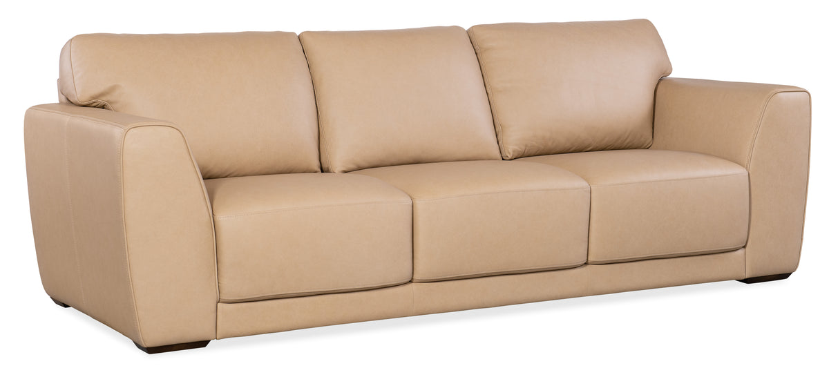a tan couch with three pillows