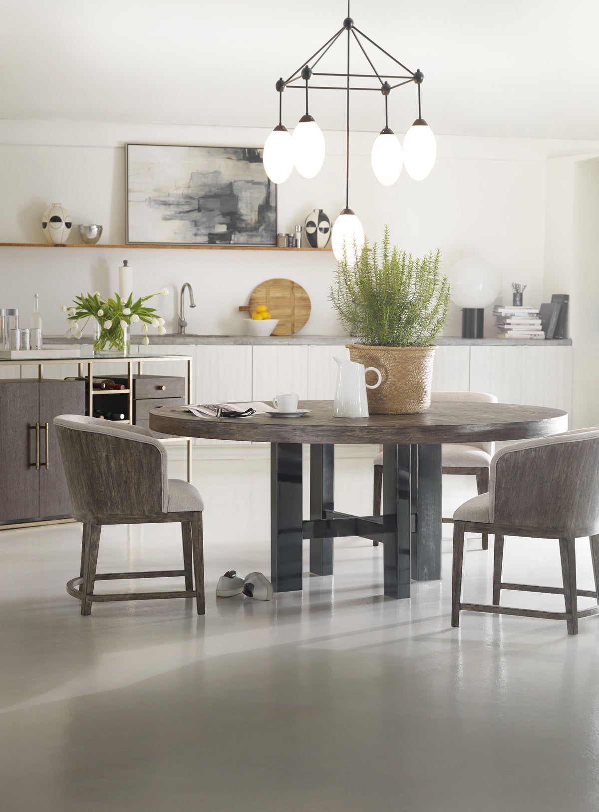 a dining table with chairs in a room with a kitchen and a sink