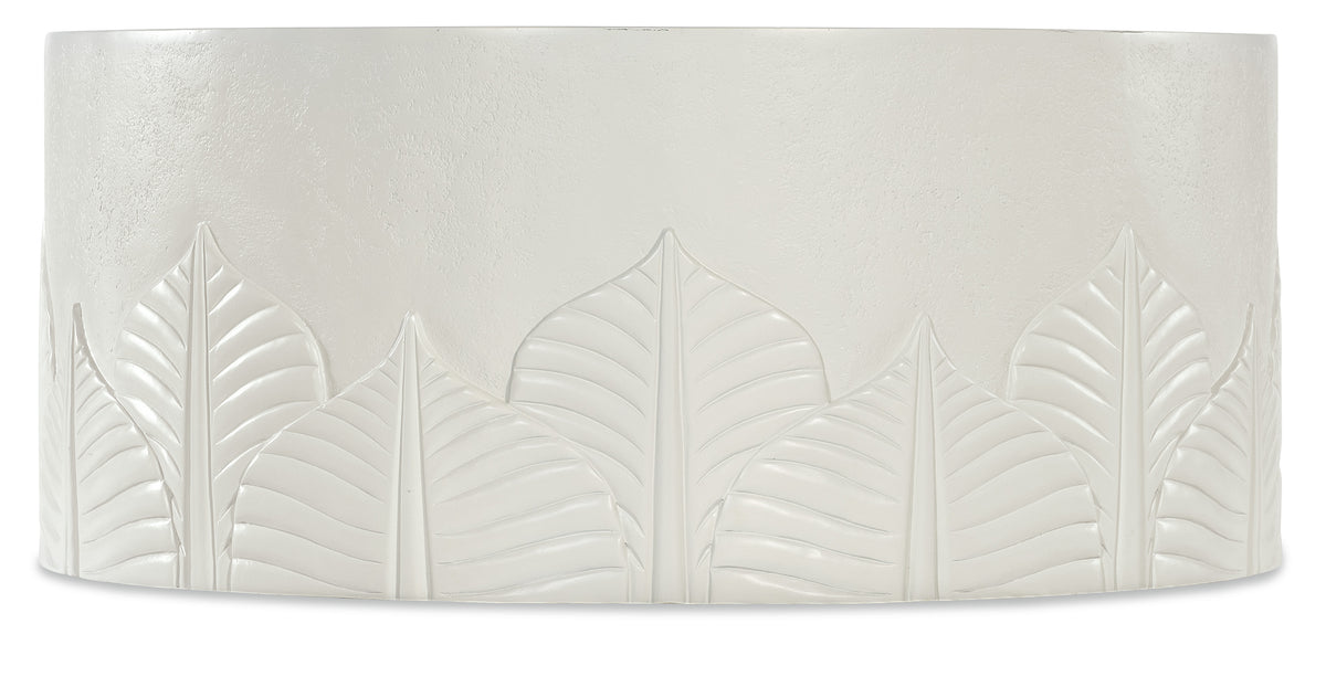 a white tile with leaves carved on it