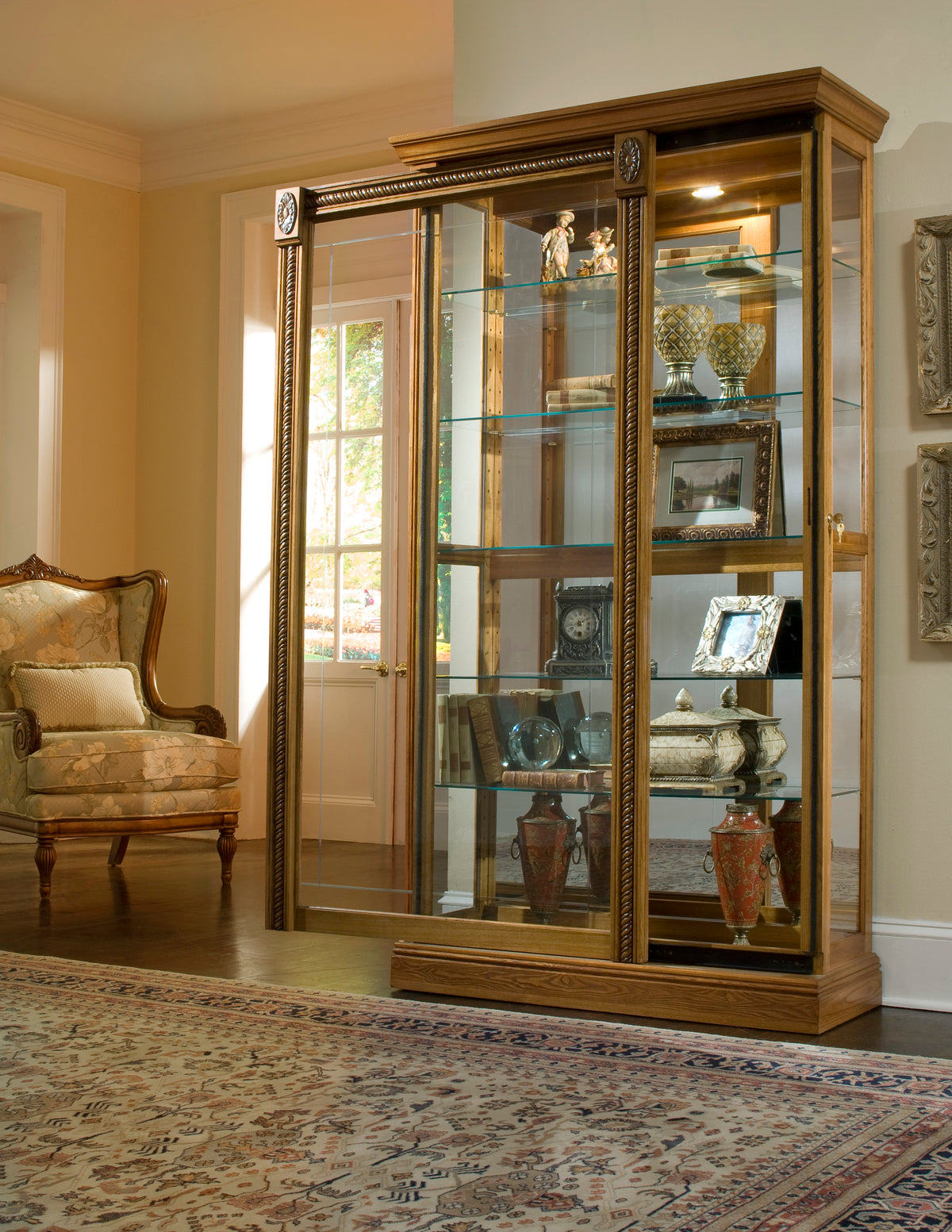 a glass cabinet with shelves and a chair in the background