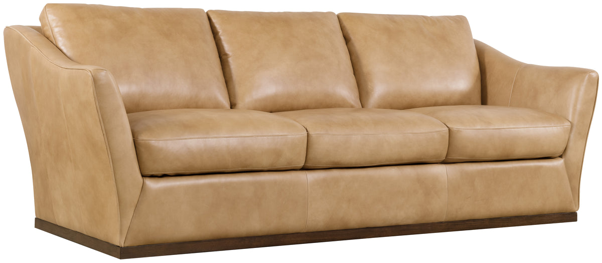 a tan leather couch with two pillows