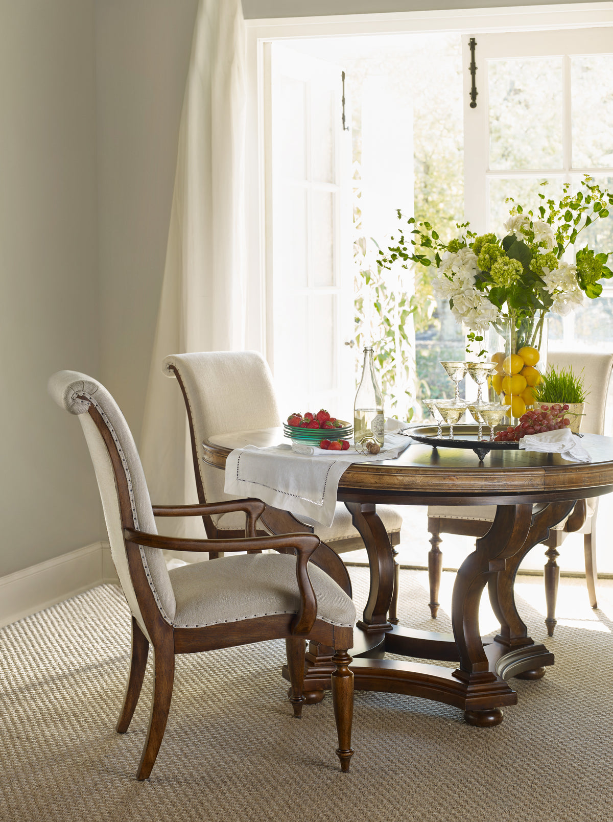 a table with a vase of flowers and a chair in a room