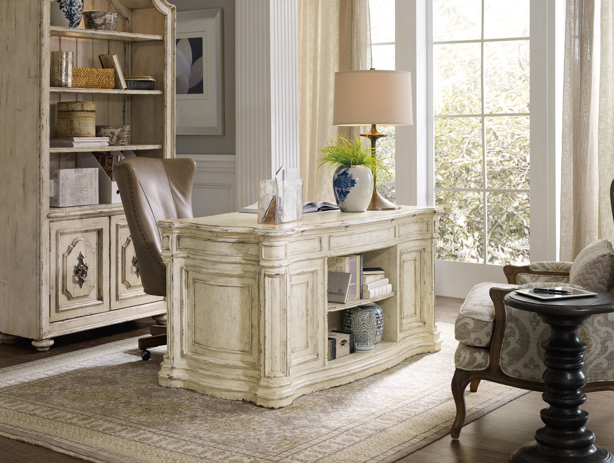 a white desk with a lamp and a bookcase in a room