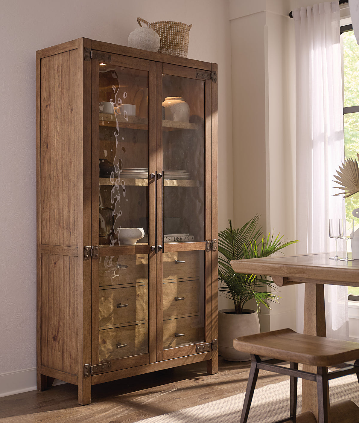 a wooden cabinet with glass doors and a table