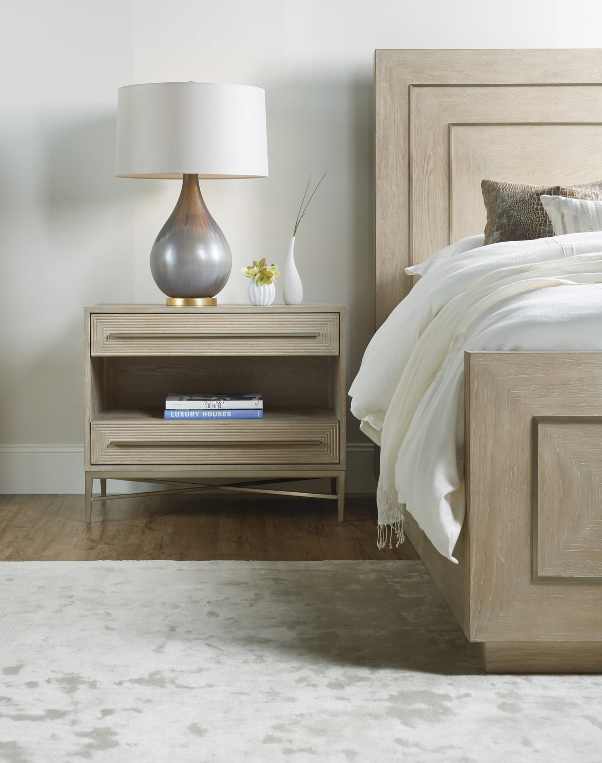 a lamp on a nightstand next to a bed