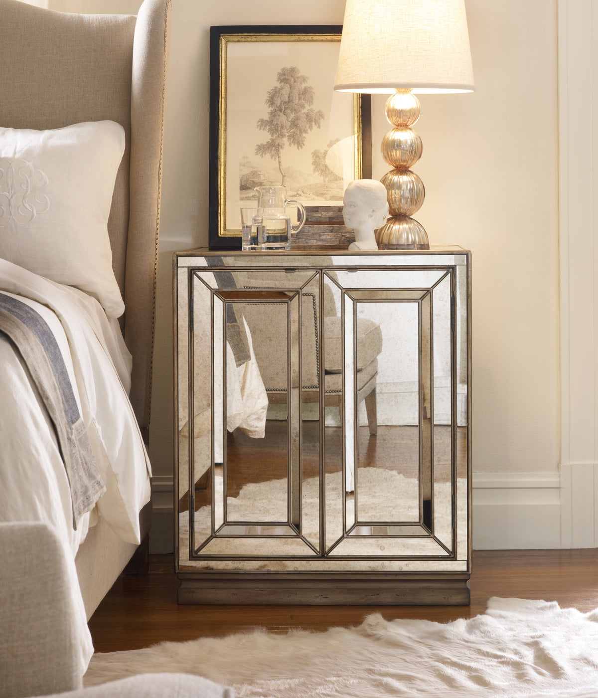 a mirror table next to a bed