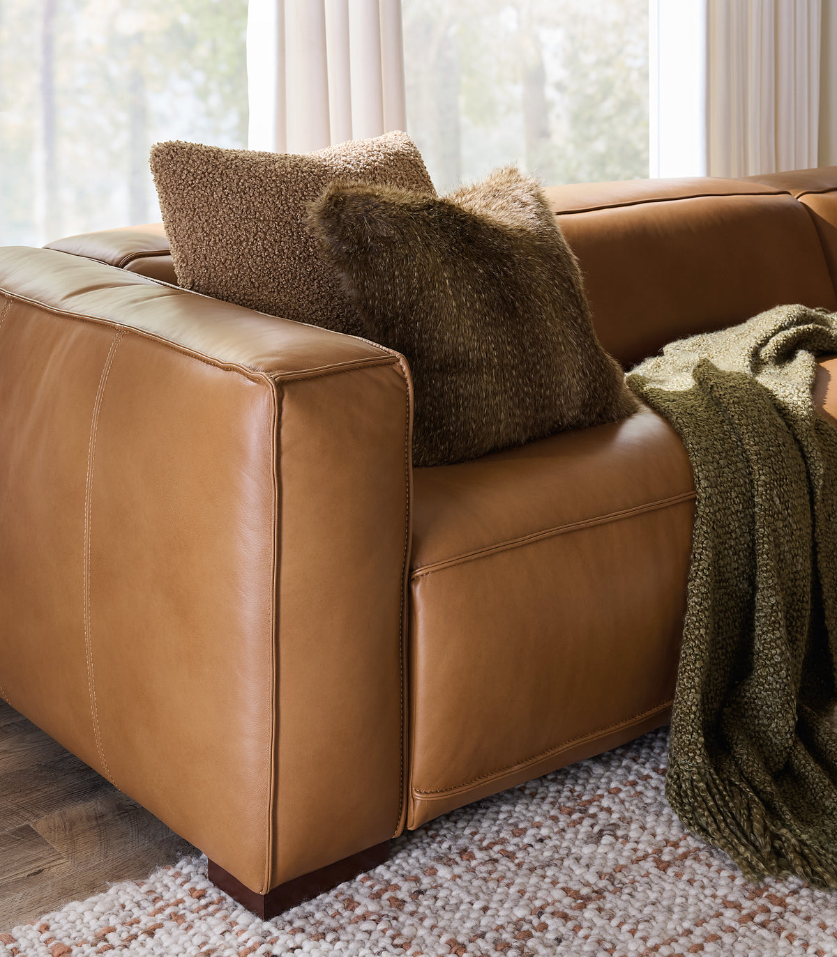 a brown couch with pillows and a blanket on it