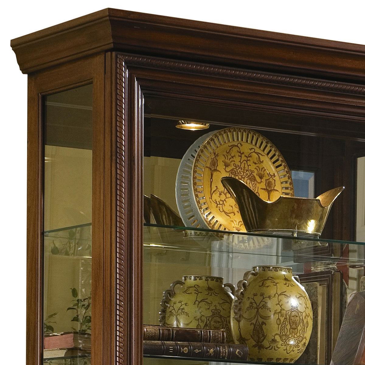 a glass cabinet with a gold plate and vases
