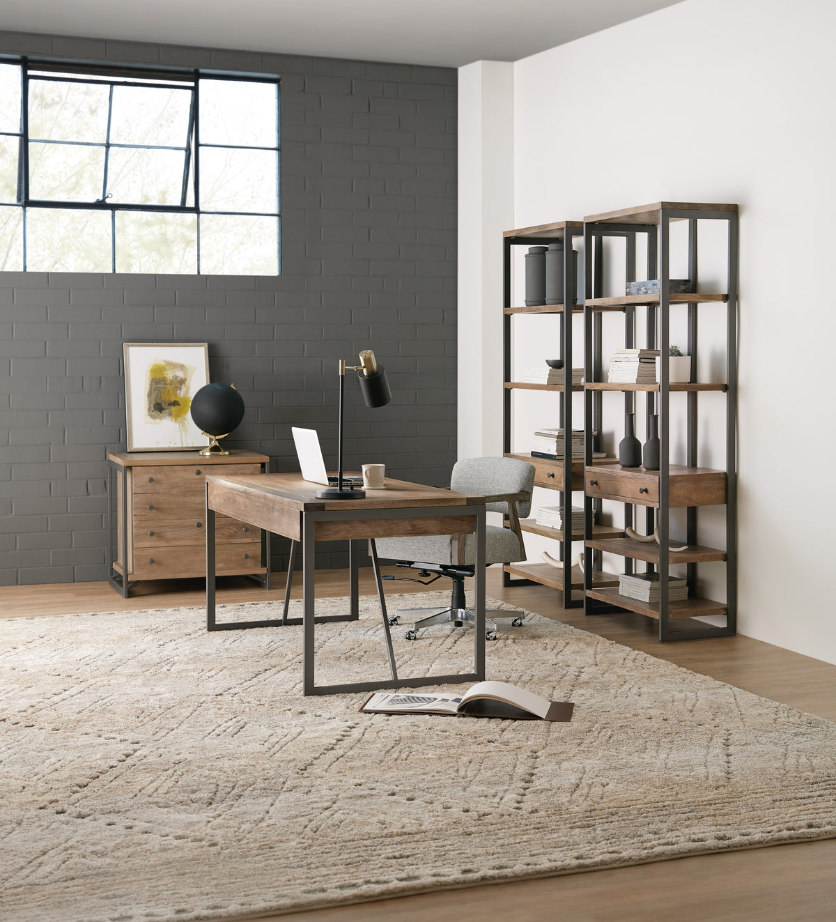 a desk in a room with a rug and a bookcase