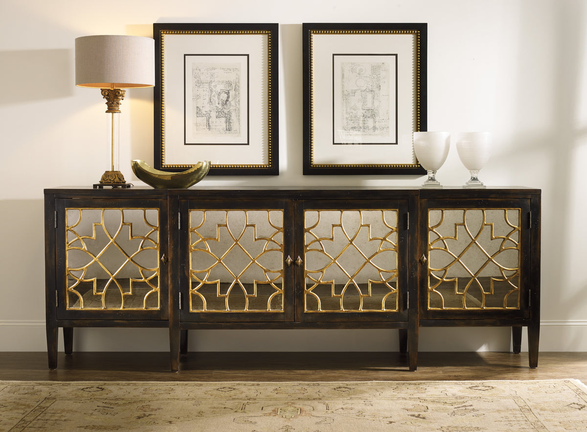 a sideboard with a lamp and pictures on the wall