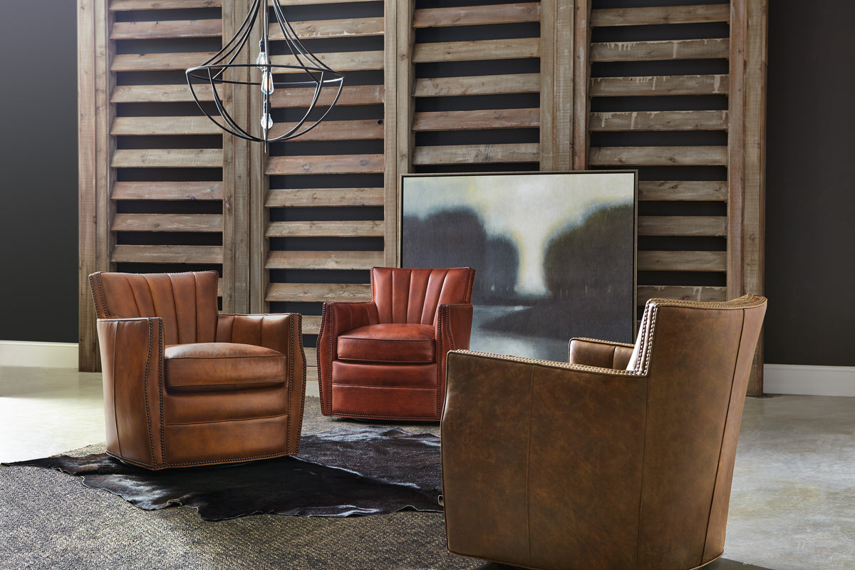 a room with leather chairs and a picture from a chandelier