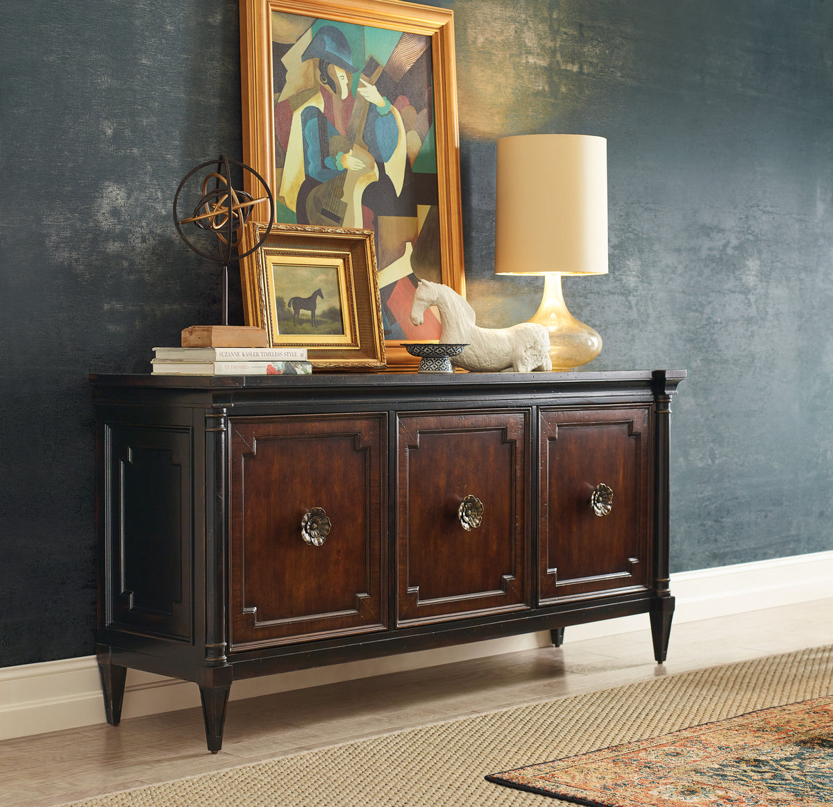 a sideboard with a lamp and a picture frame on it