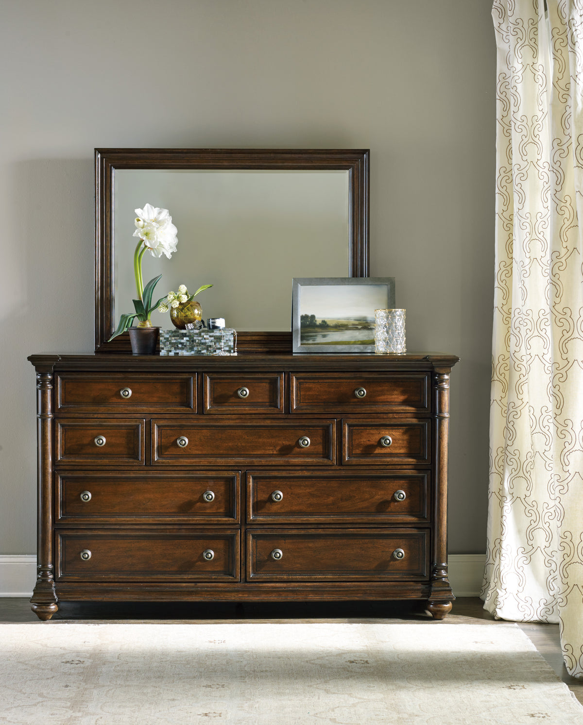 a dresser with a mirror and a flower on top