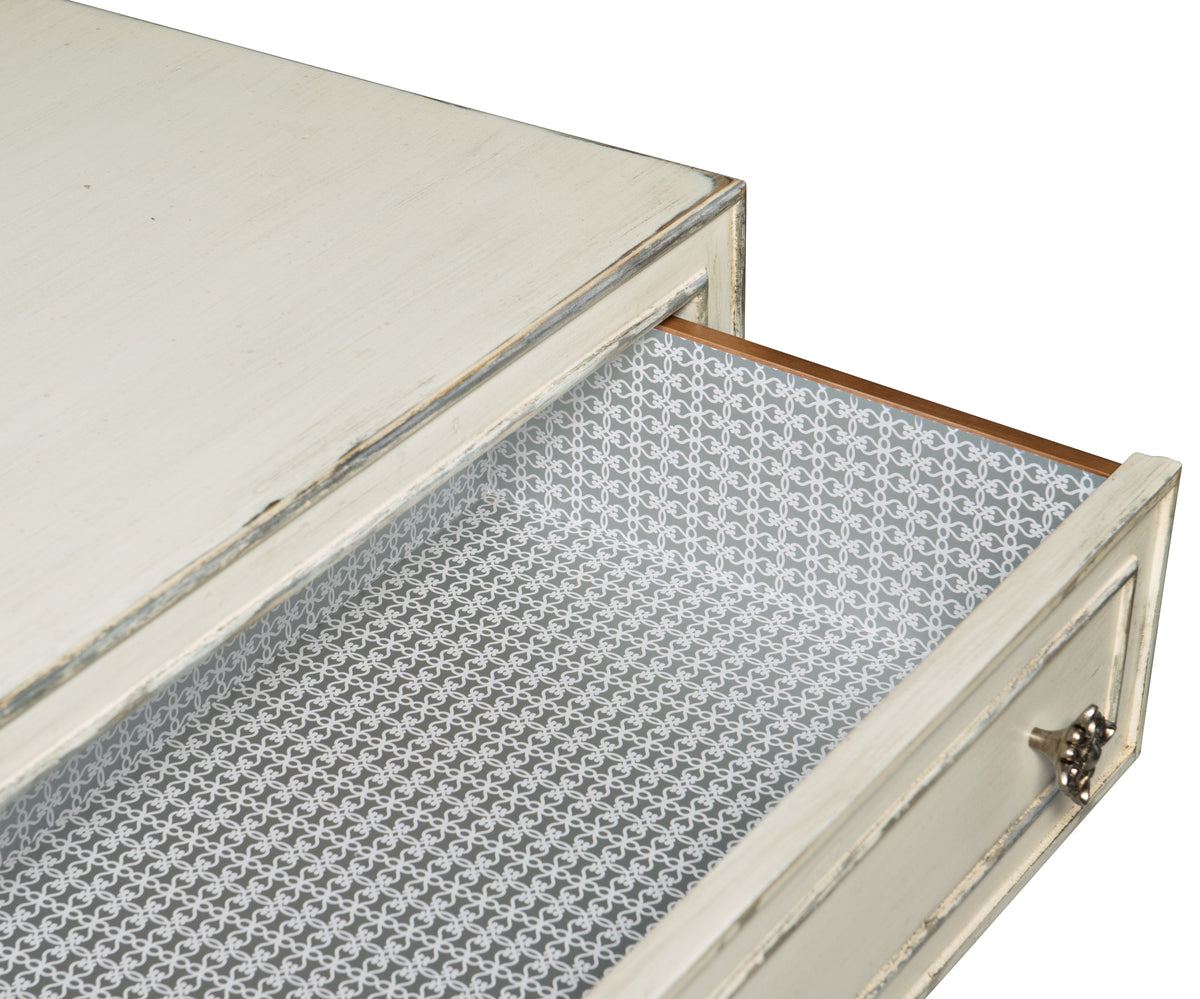 a white drawer with a patterned paper inside