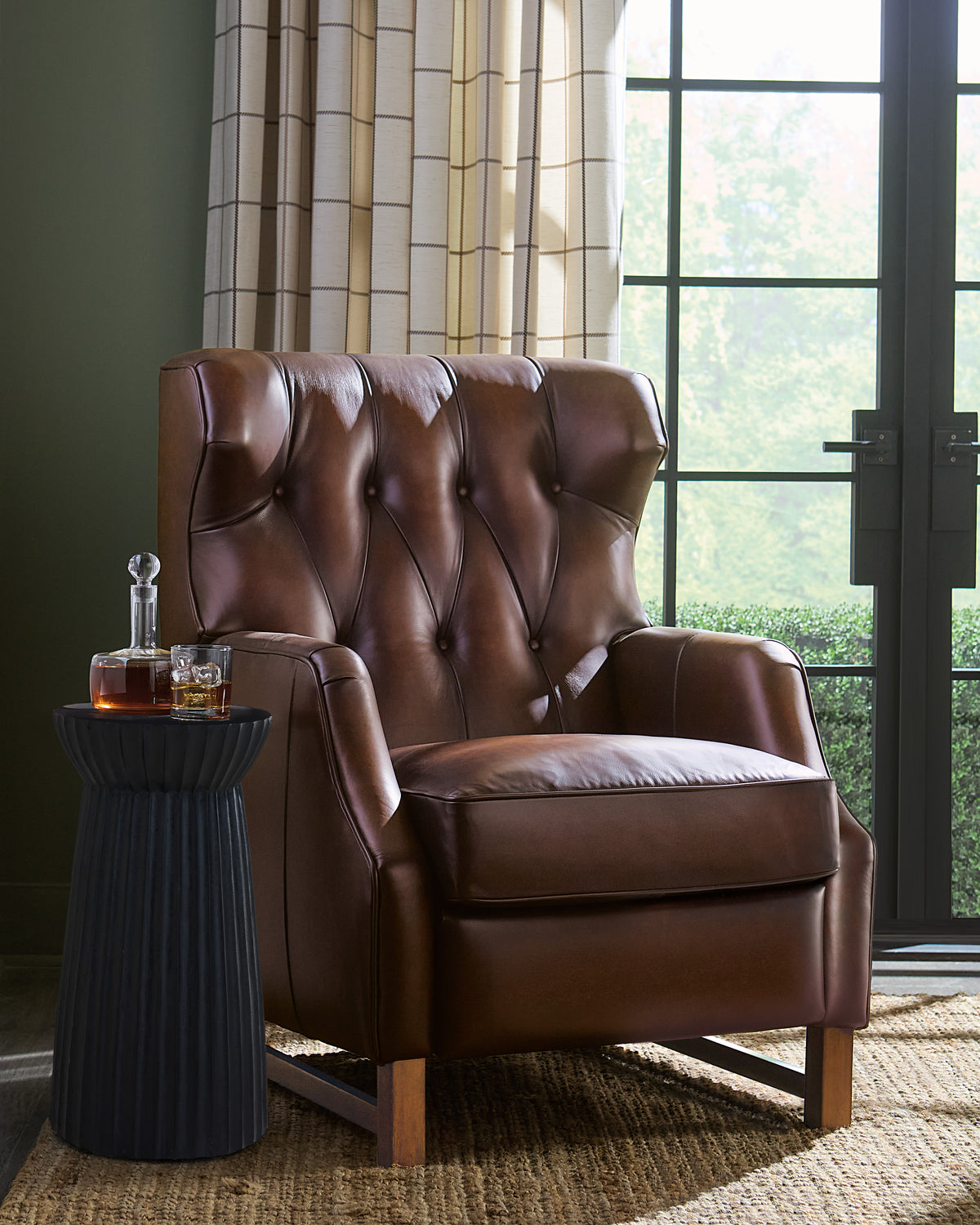 a brown leather chair next to a table