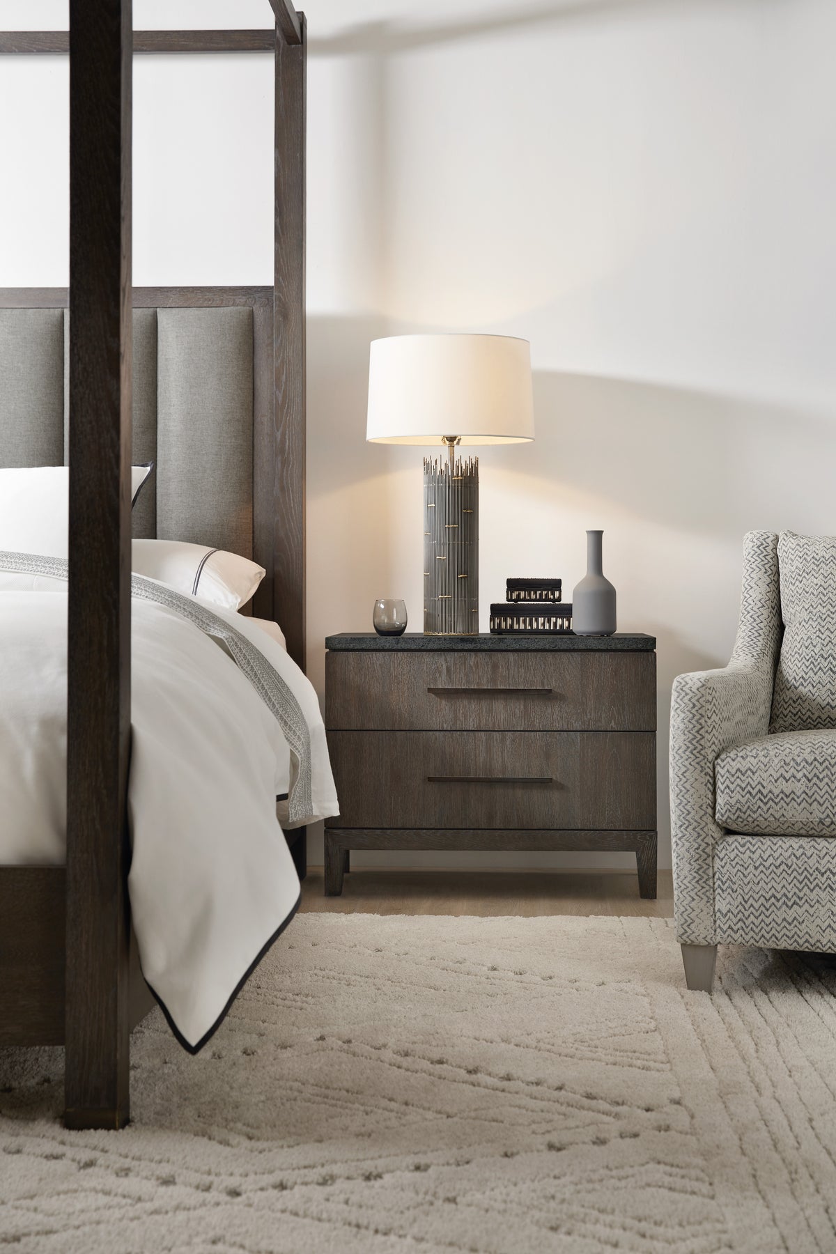 a lamp on a nightstand next to a bed