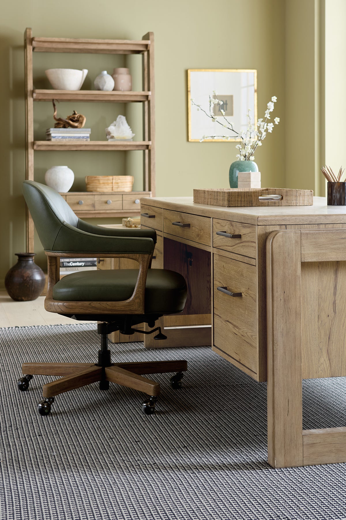 a desk with a chair and a vase on it