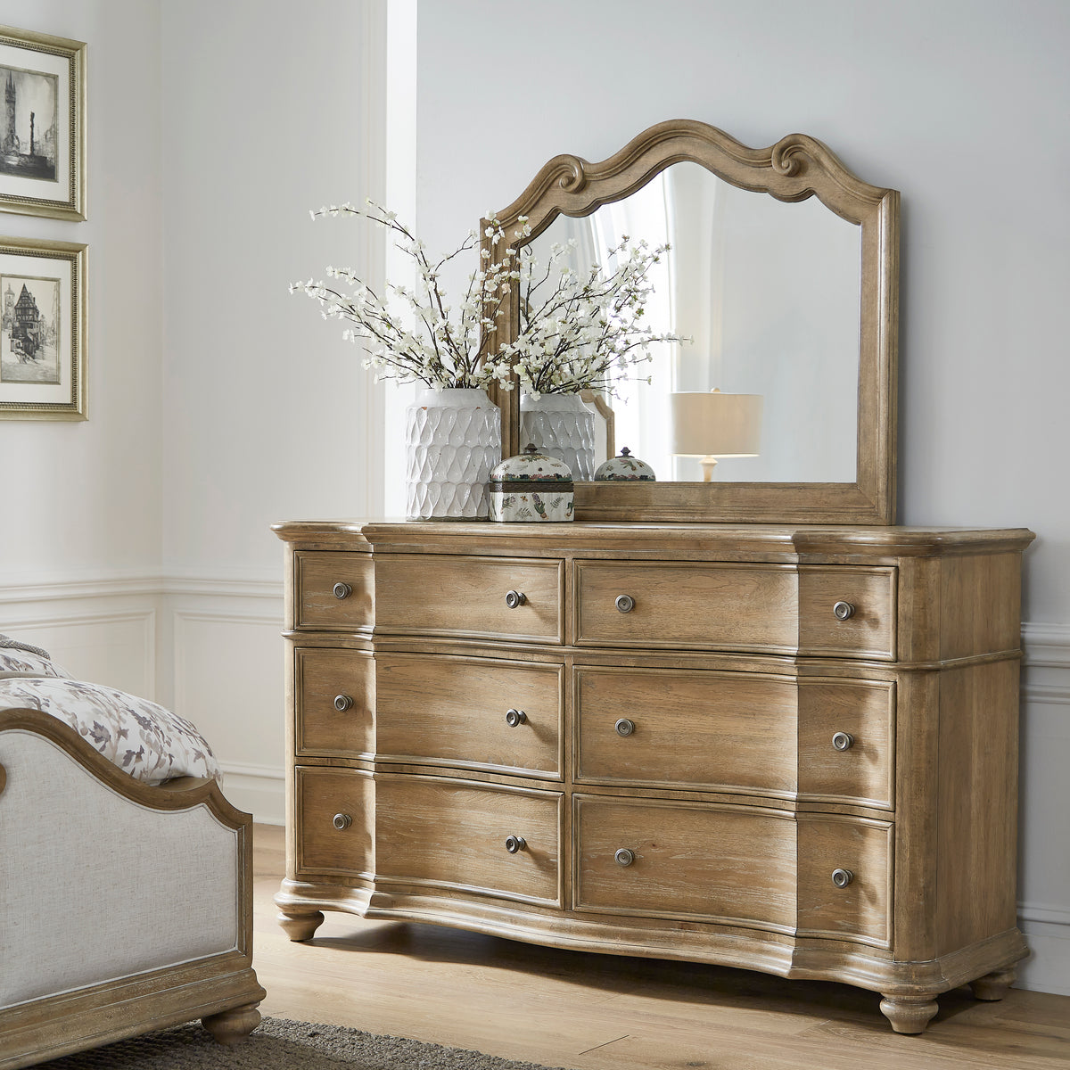 a dresser with a mirror and a vase of flowers on top