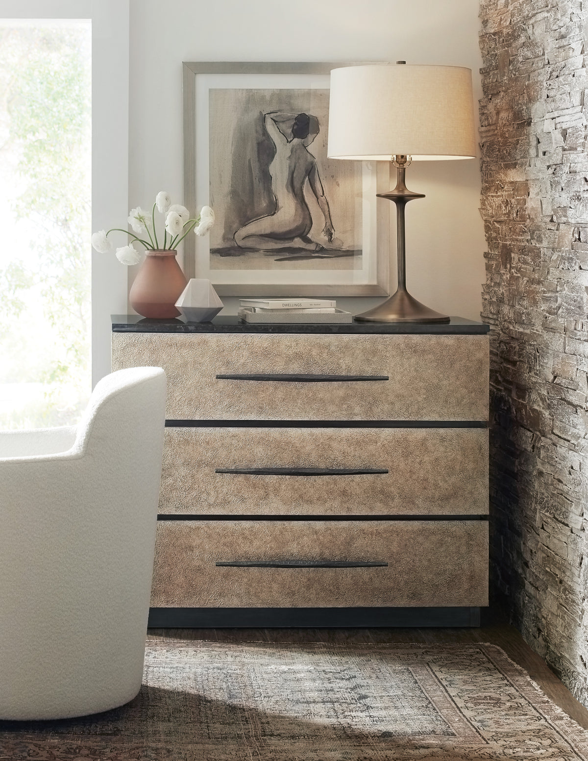 a dresser with a lamp and a painting on it
