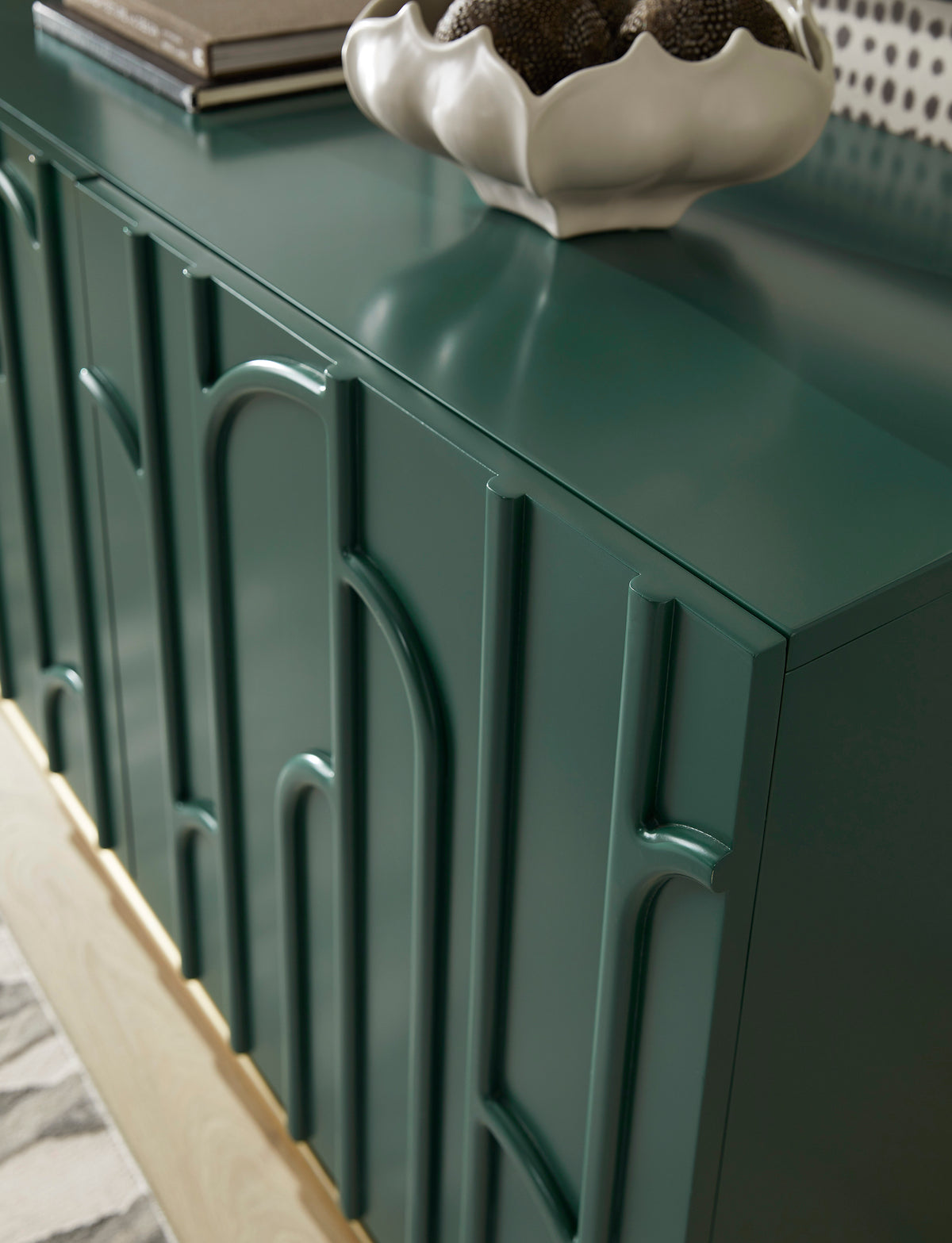 a green cabinet with a white vase on top
