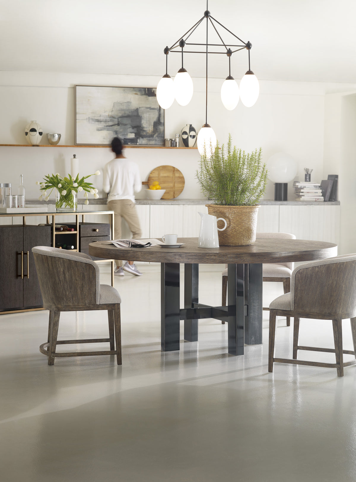 a dining table in a room with a person standing in the background