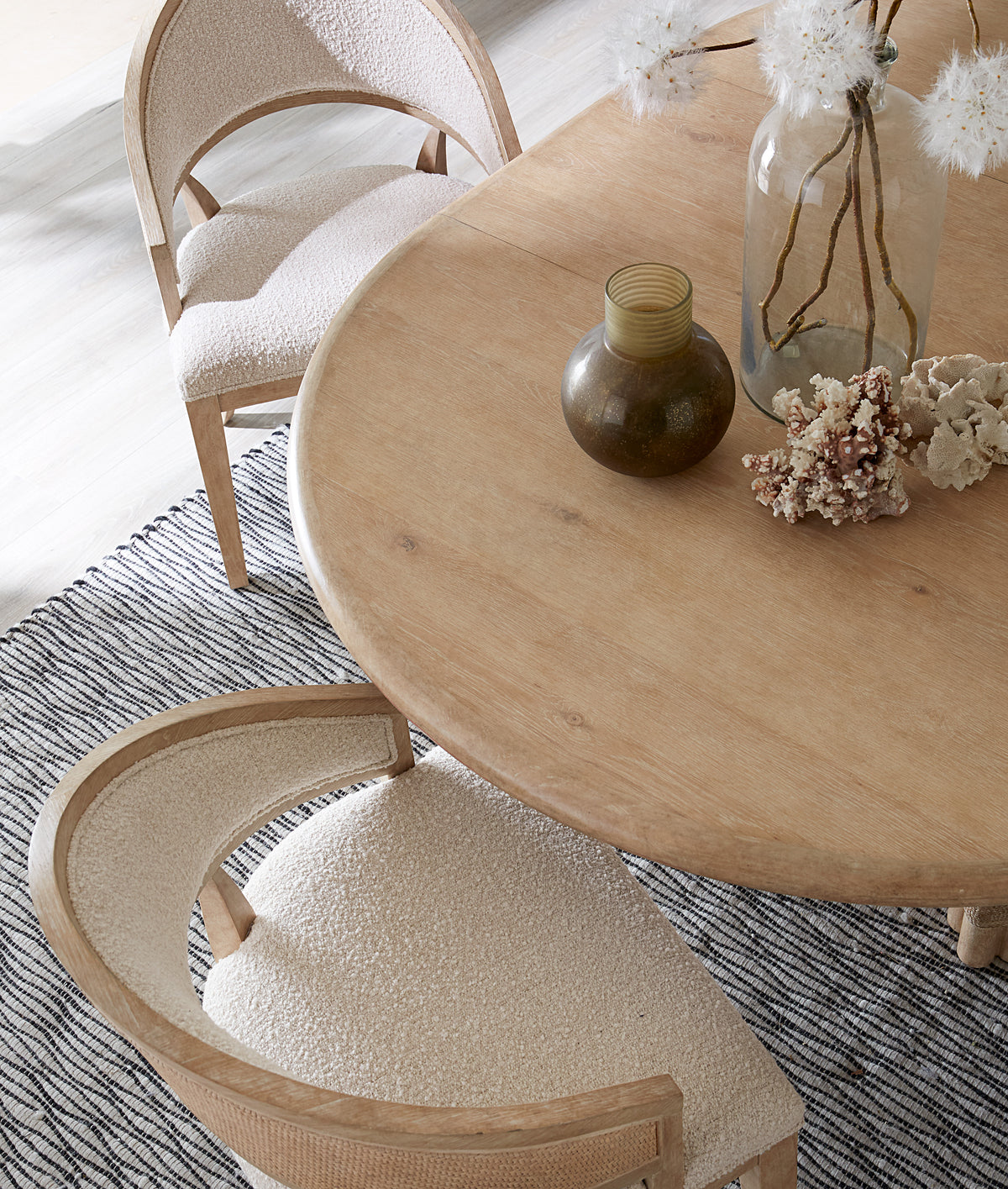 a table with a vase of flowers and a chair