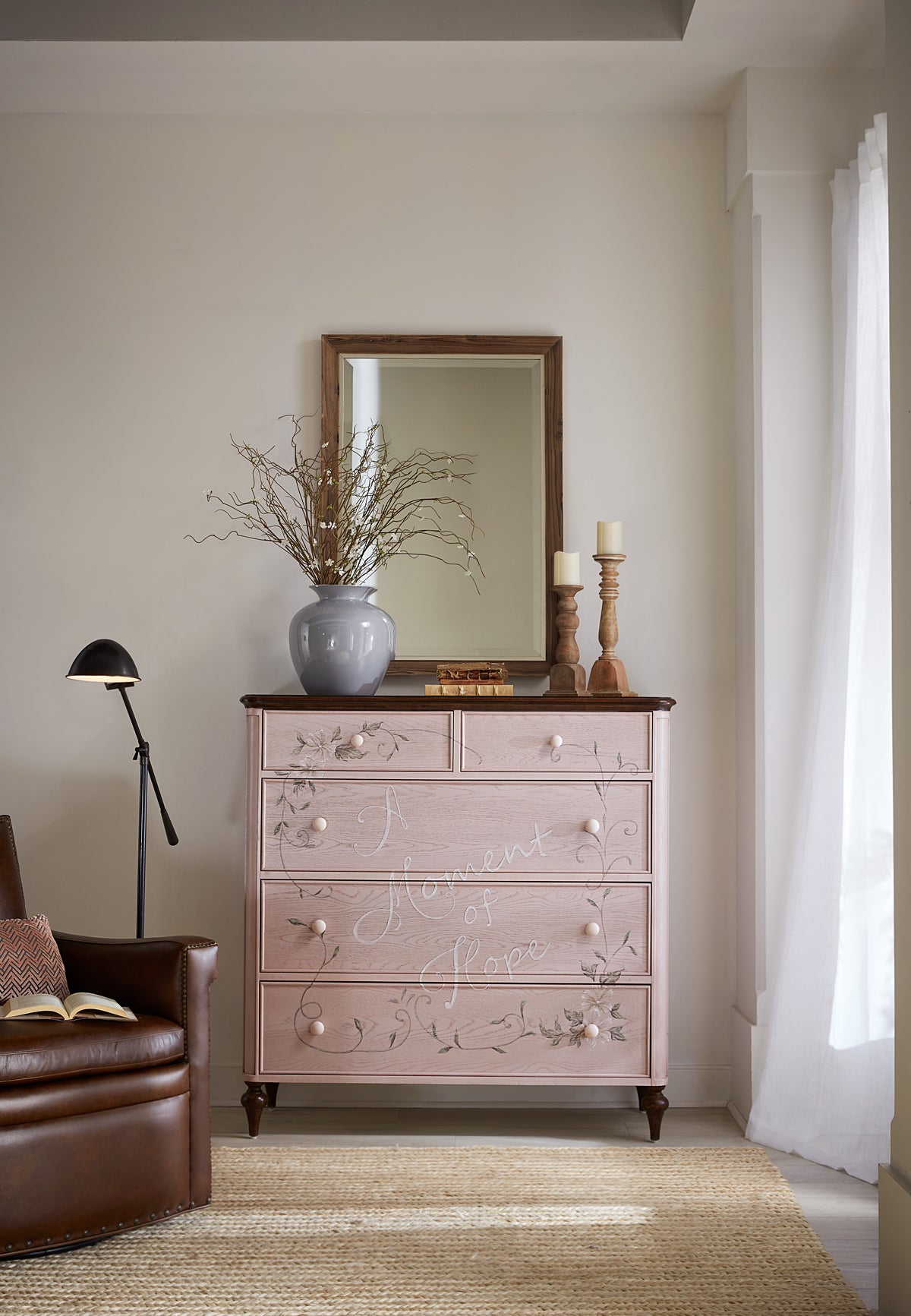 a dresser with a mirror and a vase on top