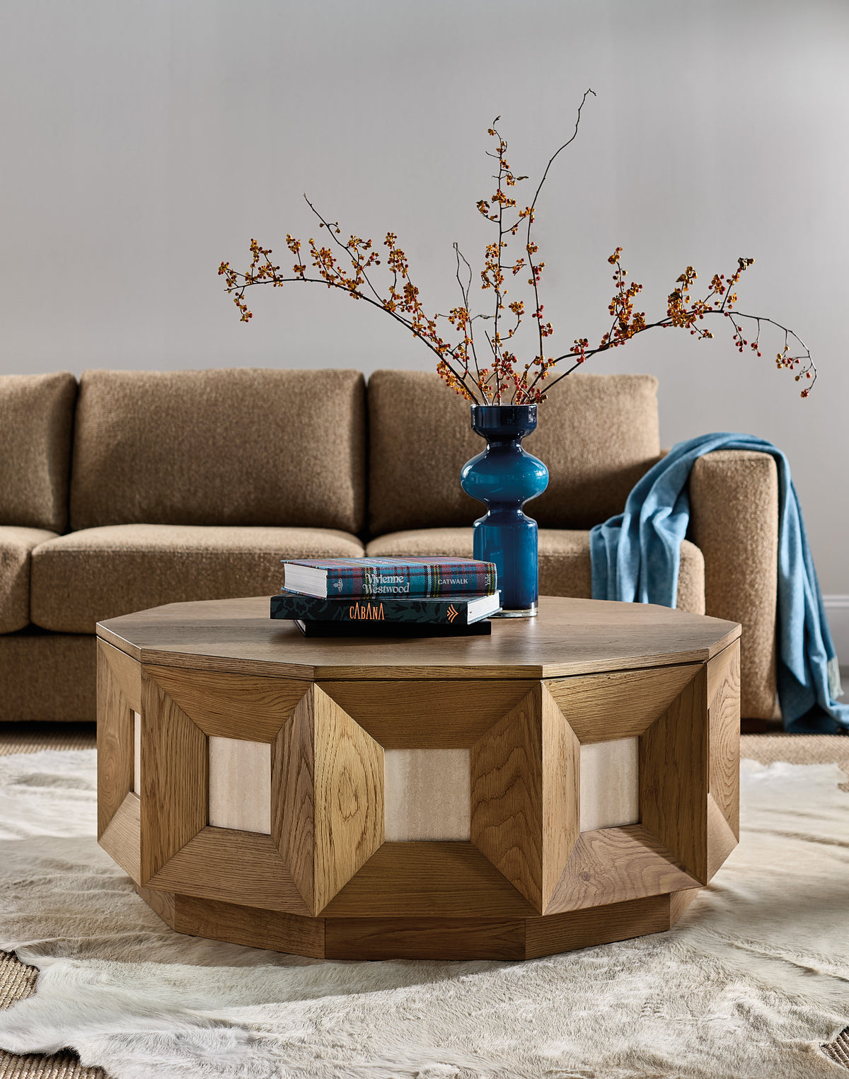 a coffee table with books and a vase of flowers in it