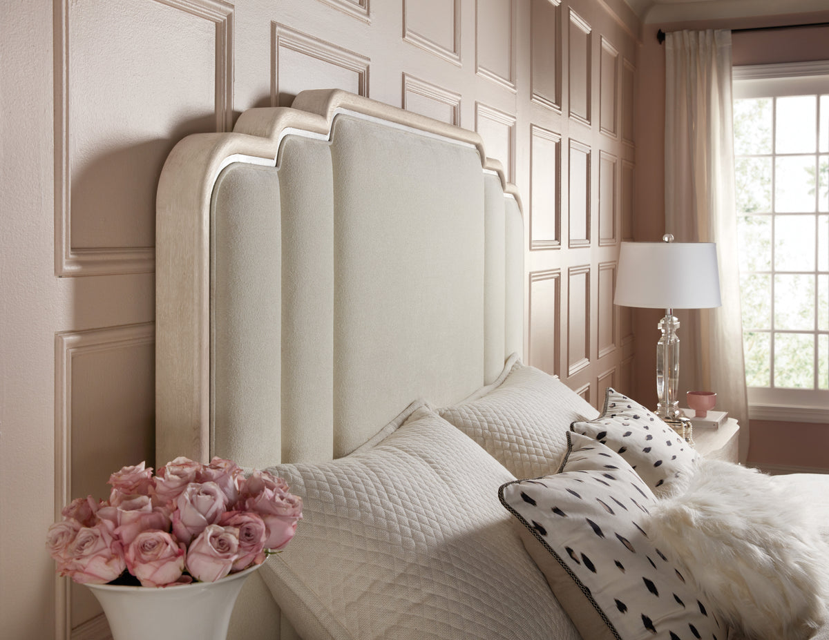 a bed with pillows and a vase of flowers