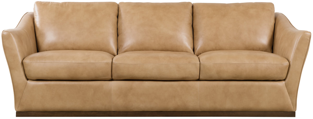 a tan leather couch with two pillows