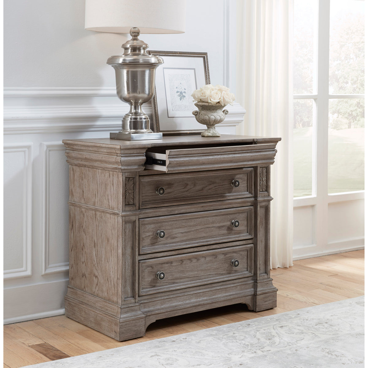 a dresser with a lamp and a picture on it