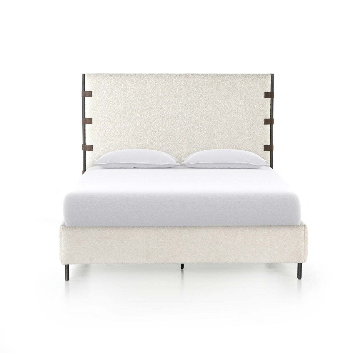a bed with white fabric and wood headboard