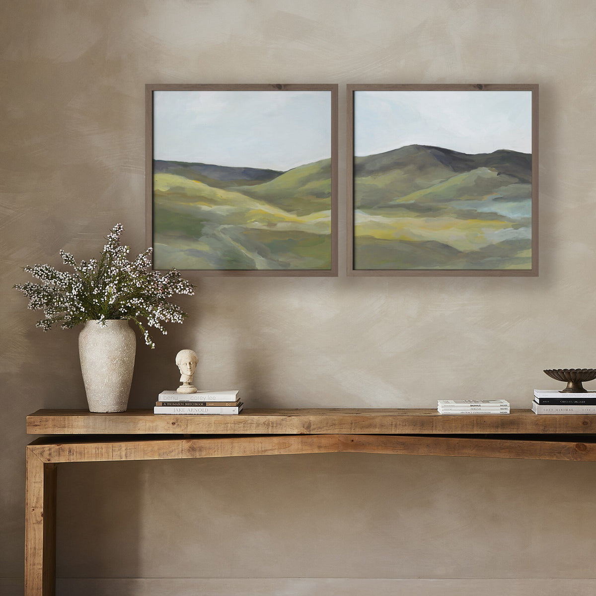 a table with a vase of flowers and a painting on the wall