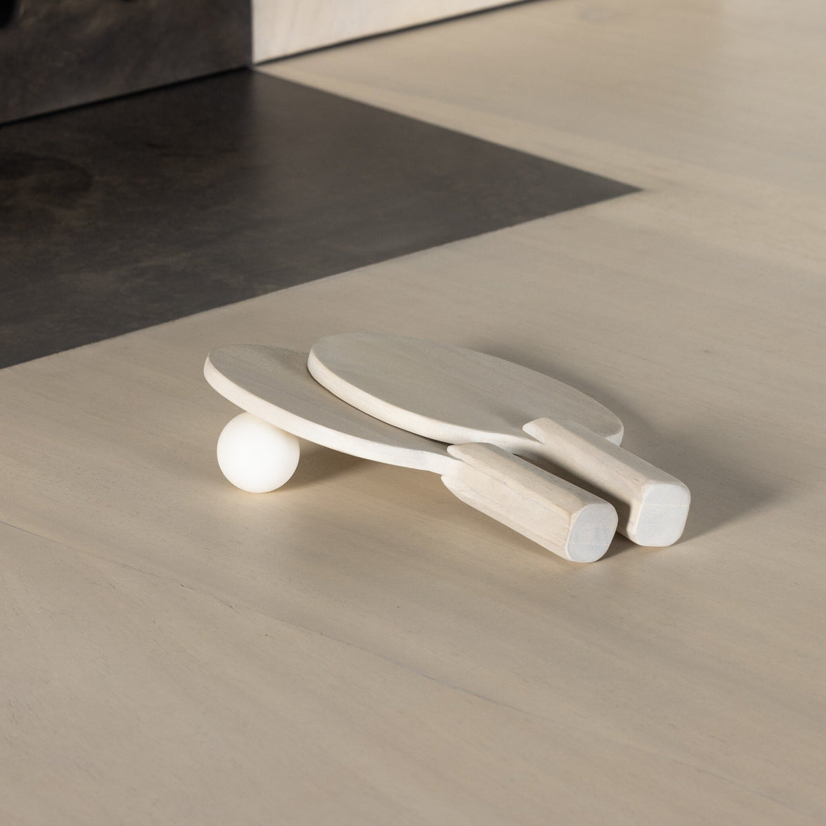 a wooden paddle and ball on a table