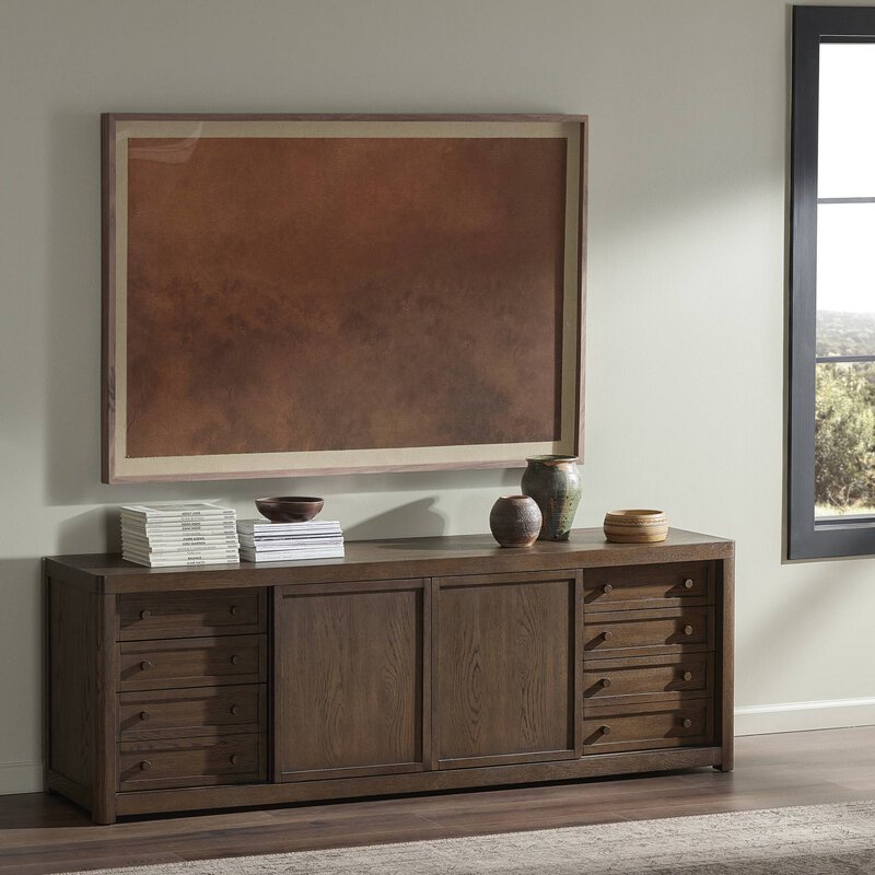 a brown cabinet with a painting on the wall