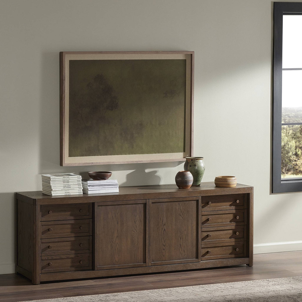 a wooden dresser with a painting on the wall