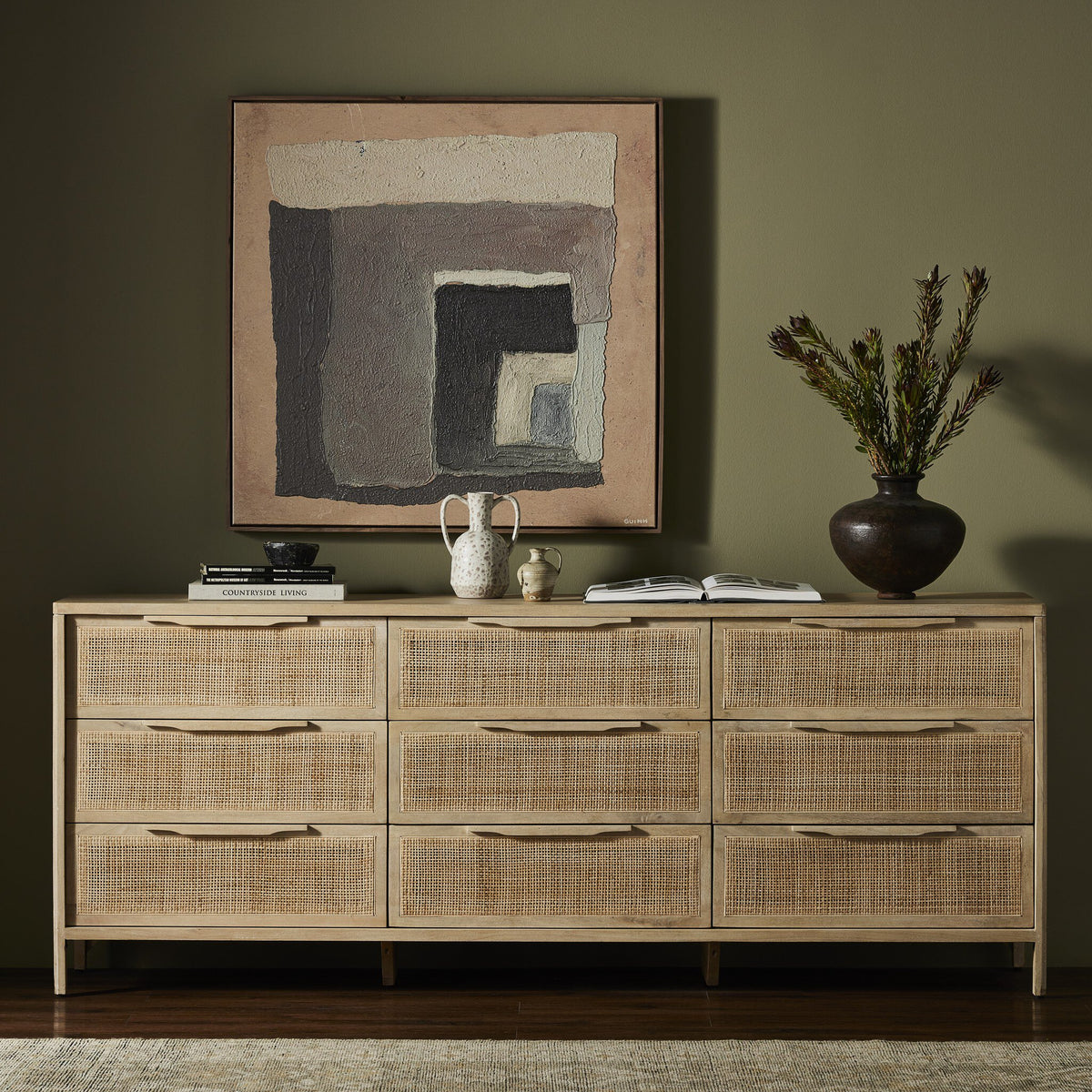 a dresser with a painting on the wall