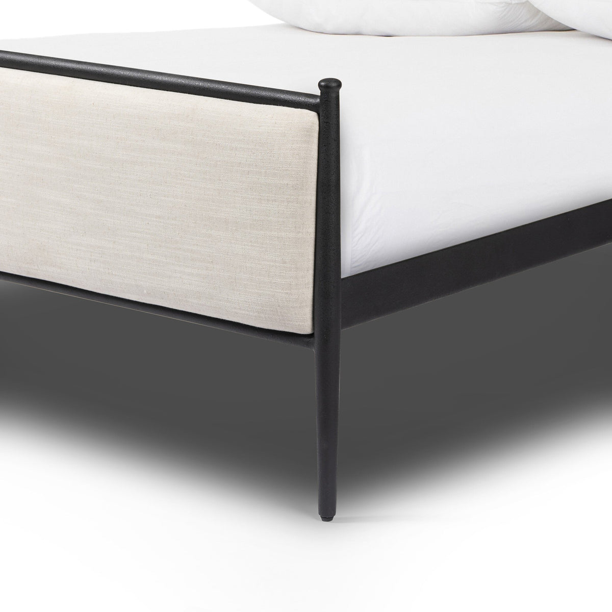 a bed with white sheets and a black frame
