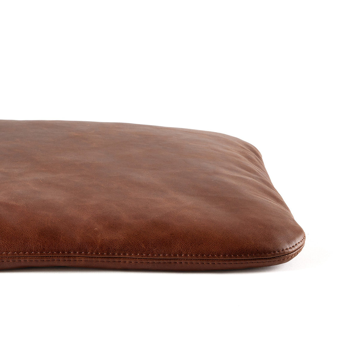 a brown pillow on a white background