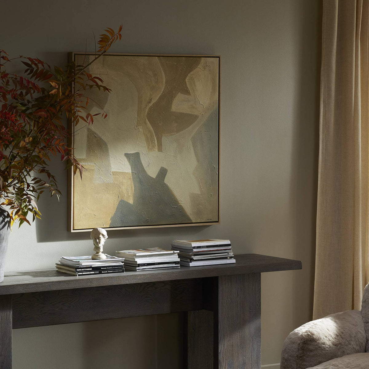 a table with books and a painting on the wall