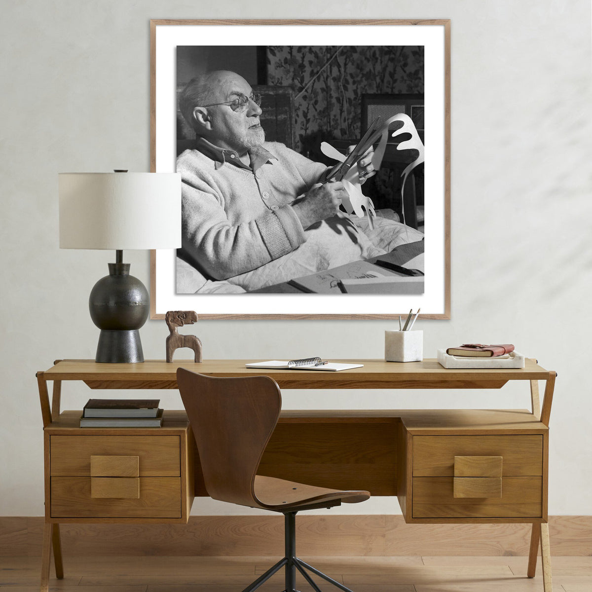 a framed picture of a man sitting on a desk