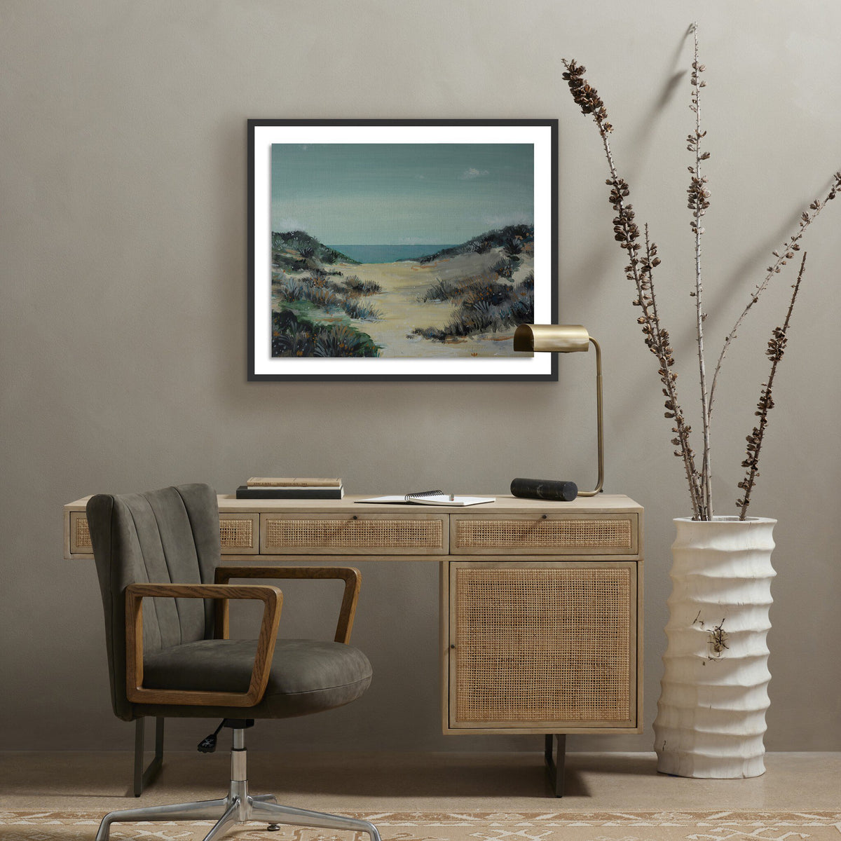 a desk with a chair and a painting on the wall