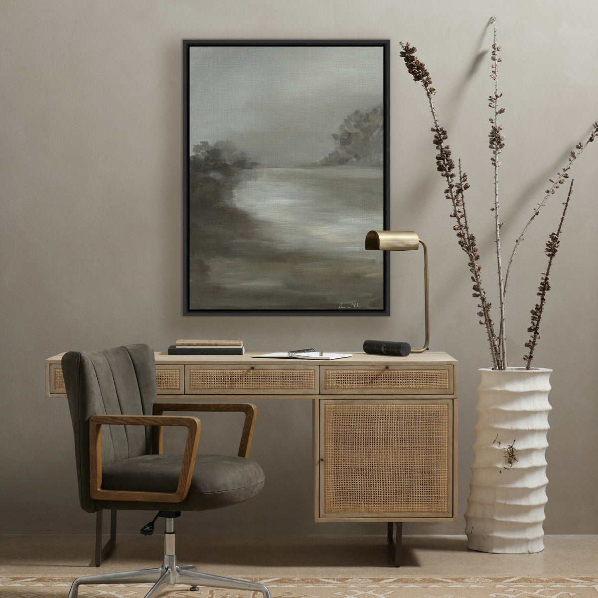 a desk with a chair and a painting on the wall